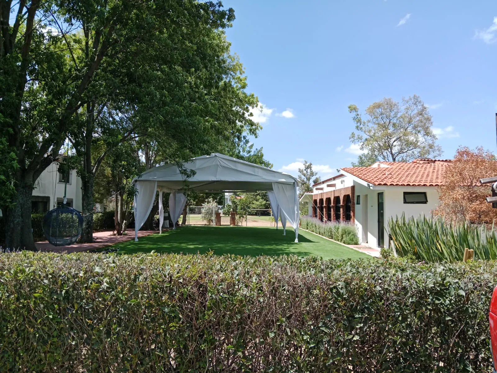 Carpa blanca montada junto a una casa de teja para un evento en Querétaro