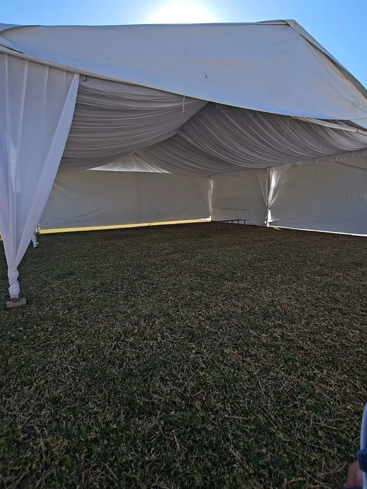 Interior de una carpa con paredes cerradas y techo drapeado en tela blanca